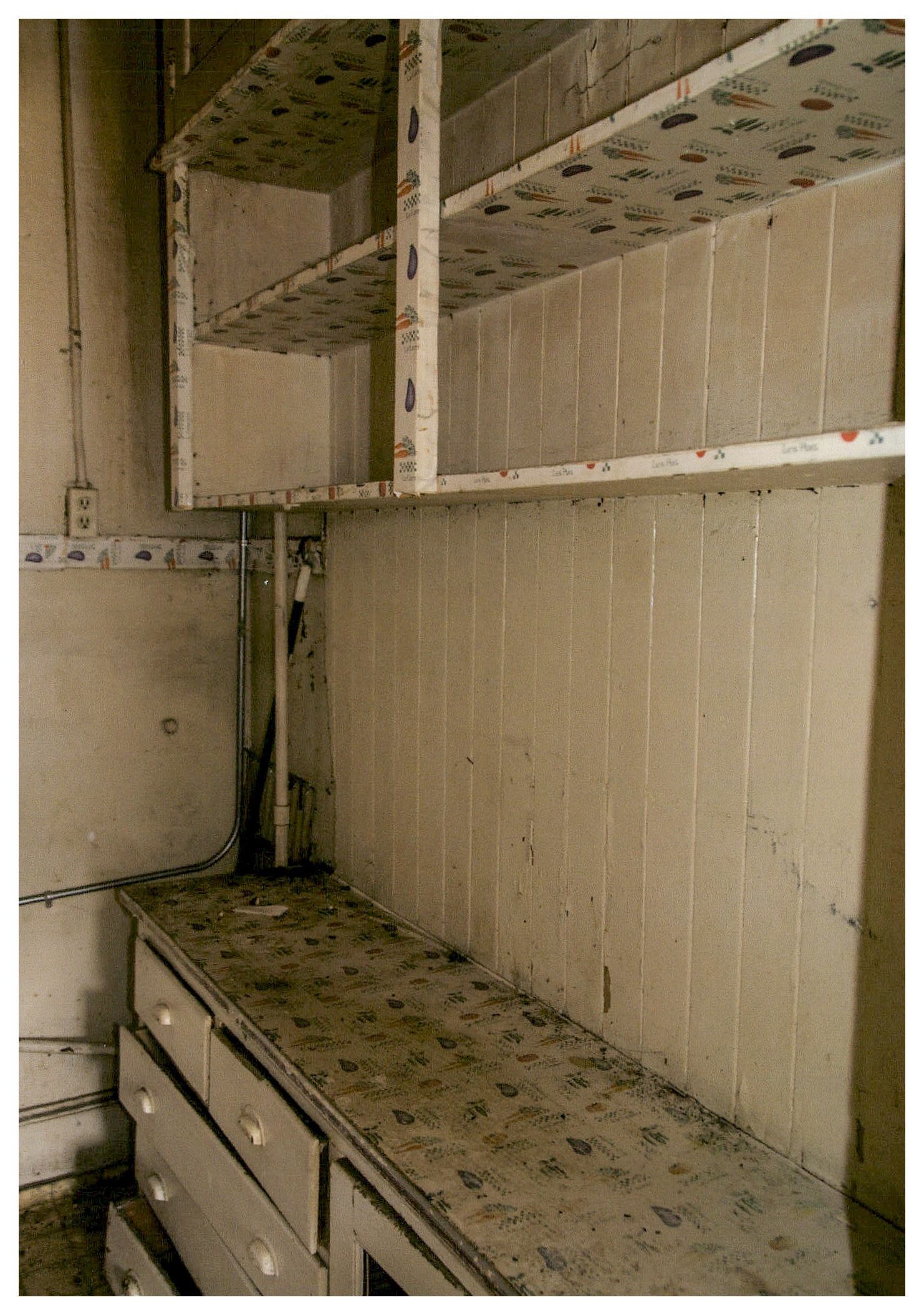 Before: apartment kitchens before rehabilitation with open shelving and narow counters.
